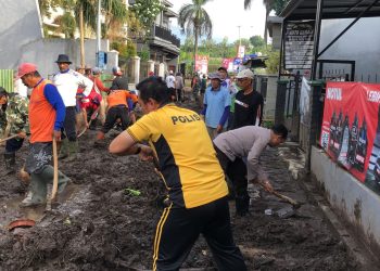 Sinergitas Polres Batu Bersama TNI dan Warga Bersihkan Lumpur Akibat Banjir Lalulintas Kembali Lancar
