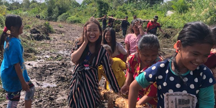 Satgas TMMD Kodim 0426/Tulang Bawang Bersama Anak-anak Sungai Badak Kumpulkan Kayu untuk Pembangunan Talud
