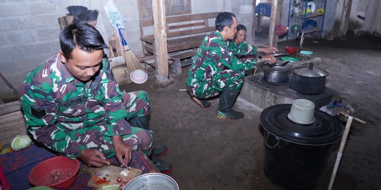 Kebersamaan TMMD Ke 127 Kodim 0808/Blitar, “Anggota Satgas Bantu Warga Memasak Di Dapur”